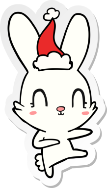 Bir insan tarafından çizilmiş Noel Baba şapkasıyla dans eden bir tavşanın çizilmiş şirin el yazısı.