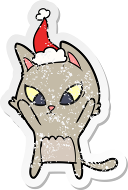 Kafası karışmış bir el, insan tarafından çizilmiş Noel Baba şapkası takan bir kedi çıkartması çizmiş.