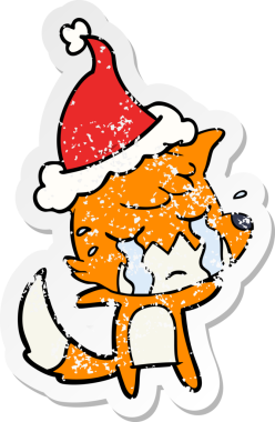 Ağlayan tilki eli, bir insan tarafından çizilmiş Noel Baba şapkasının üzgün çıkartması çizilmiş.