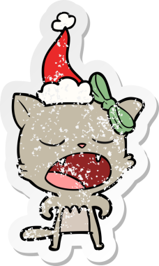 Bir insan tarafından çizilmiş Noel Baba şapkası giymiş kedi miyavlıyor.