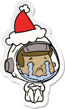 Bir insan tarafından çizilmiş Noel Baba şapkası giyen ağlayan bir astronotun el yazısı.