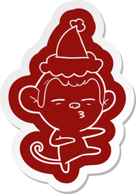 Bir insan tarafından çizilmiş Noel Baba şapkası giyen şüpheli bir maymunun garip karikatür çıkartması.