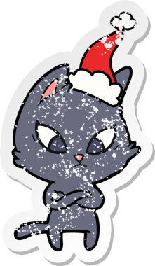 Kafası karışmış bir el, insan tarafından çizilmiş Noel Baba şapkası takan bir kedi çıkartması çizmiş.