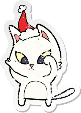 Kafası karışmış bir el, insan tarafından çizilmiş Noel Baba şapkası takan bir kedi çıkartması çizmiş.