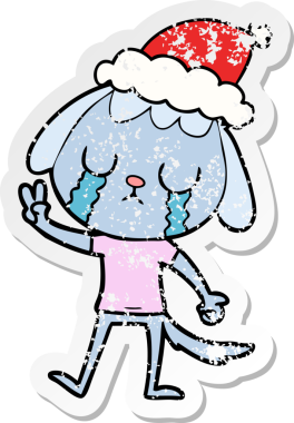 Sevimli bir el, kederli bir çıkartma çizmiş. Ağlayan bir köpek, Noel Baba şapkası takmış bir insan tarafından çizilmiş.