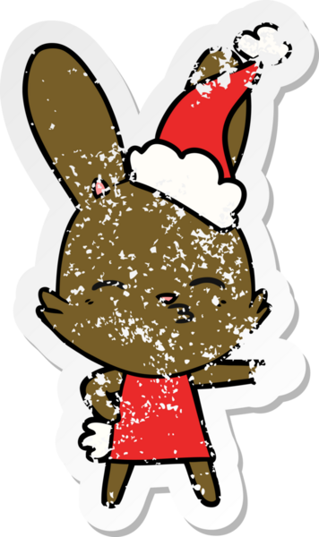 Meraklı tavşanlı el, insan tarafından çizilmiş Noel Baba şapkası giymiş bir karikatür çizmiş.