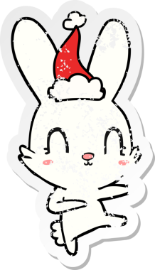 Bir insan tarafından çizilmiş Noel Baba şapkasıyla dans eden bir tavşan çizilmiş.