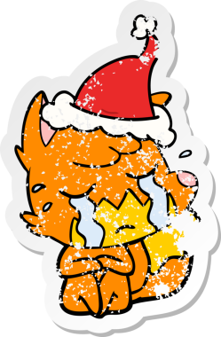 Ağlayan tilki eli, bir insan tarafından çizilmiş Noel Baba şapkasının üzgün çıkartması çizilmiş.