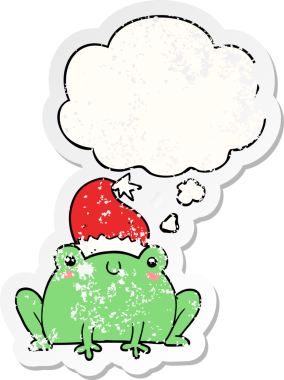 Düşünce baloncuğu olan şirin bir Noel kurbağası. Bir insan tarafından çizilmiş yıpranmış bir çıkartma.