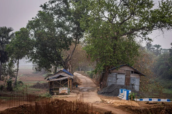 Kırsal köy ve sarı çamur yolu yaz manzarası. Hindistan kırsalında. Bankura Batı Bengal Hindistan Güney Asya Pasifik