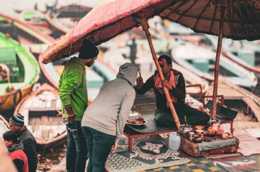 Couple taking blessings from sadhu in Varanasi ghat in morning. Varanasi Uttar Pradesh India South Asia December 21 2023 clipart