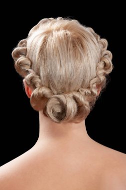 Genç bir kadının geçmişe bakış açısı. Beyaz, çıplak, sarışın bir kadının yakın plan portresi. Sarı kıvırcık saçlı. Şık bir saç stili. Siyah bir arkaplanda izole edilmiş