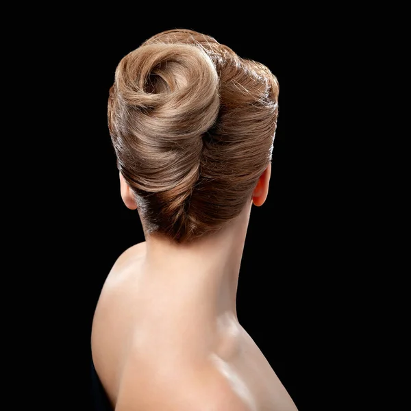 Back view of young woman. Portrait of a nude young white blonde woman. Blond styled hair. Stylish hairstyle. Isolated on a black background