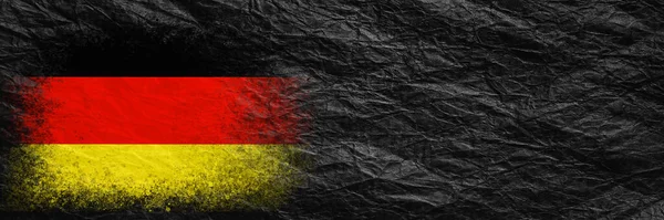 Flag of Germany. Flag is painted on black crumpled paper. Paper background. Copy space. Textured creative background