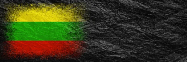Flag of Lithuania. Flag is painted on black crumpled paper. Paper background. Copy space. Textured creative background