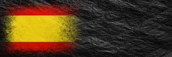 Flag of Spain. Flag is painted on black crumpled paper. Paper background. Copy space. Textured creative background