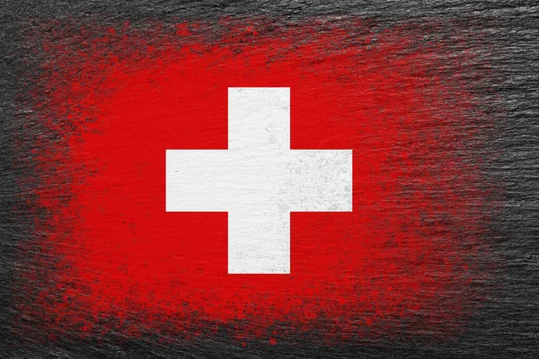 stock image Flag of Switzerland. Flag is painted on black slate stone. Stone background. Textured creative background