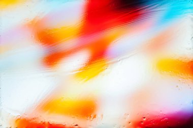 Abstract blur background. Abstract image of multicolored blurred spots and glare through wet glass. Texture of water and oil traces on glass. Creative backdrop