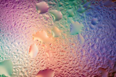 Abstract background. Abstract blur image of colored soft spots and gradients through wet glass. Texture of water drops on glass. Creative background