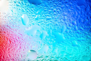 Abstract background. Abstract blur image of colored soft spots of gradients and glare through wet glass. Texture of water drops on frozen glass. Creative background