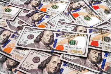 Yüz dolarlık banknotlar. Dağınık pek çok banknota yakın çekim. Bir yığın Amerikan doları. Para dokusu. Bankacılık ve finansal konsept. Tonu ayarlanmış resim