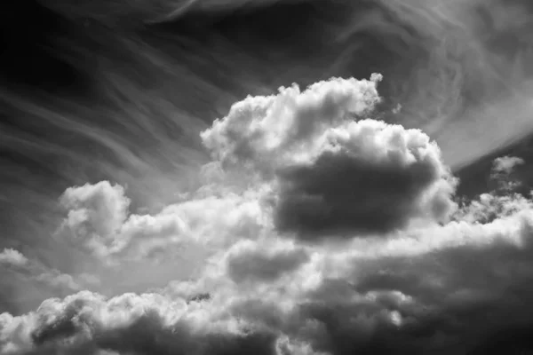 White clouds on a dark dramatic sky. Storm clouds. Black and white sky template to create atmosphere