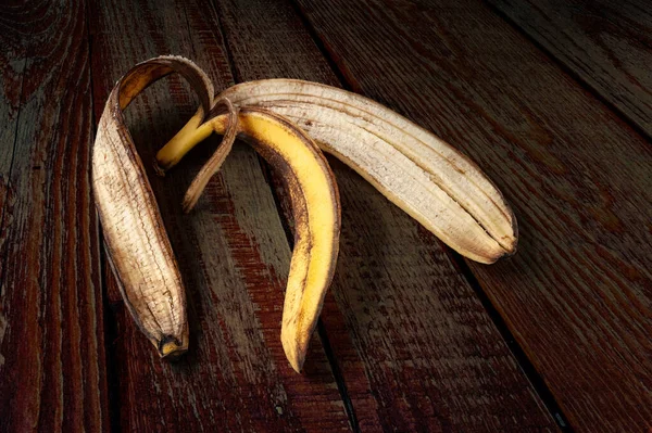 Banana peel. Close-up of an overripe banana peel on a dark wooden background. Food waste