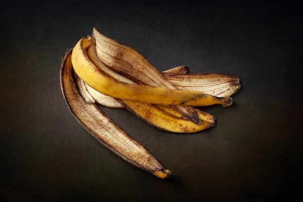 Banana peel. Peel of an overripe banana on a dark abstract background close-up. Food waste