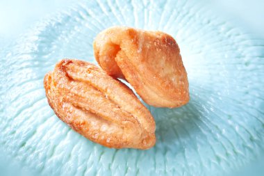 Biscuits are sprinkled with sugar. Cookies on a blue texture background. Crispy fresh pastry. Soft focus