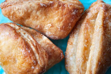Biscuits are sprinkled with sugar. Cookies on a blue texture background. Crispy fresh pastries close-up. Soft focus