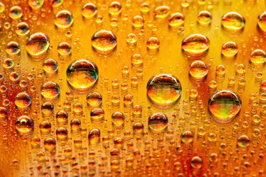 Büyük su damlaları. Soyut ıslak arka plan. Renkli makro desenli ve bir sürü damla. Gökkuşağı gradyanı. Ağır desenli görüntü. Yüzeyin derinliği. Seçici yumuşak odak