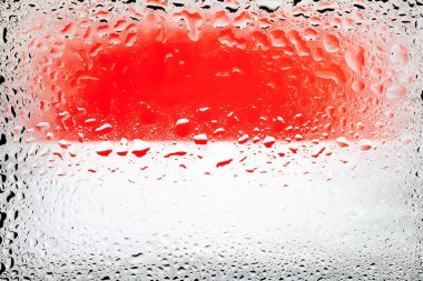 Monako bayrağı. Su damlalarının arka planında Monako bayrağı var. Yağmur damlalı bayrak. Cama sıçrıyor. Soyut arkaplan