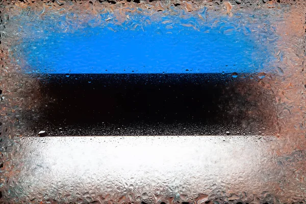 Flag of Estonia. Flag of Estonia on the background of water drops. Flag with raindrops. Splashes on glass. Abstract background