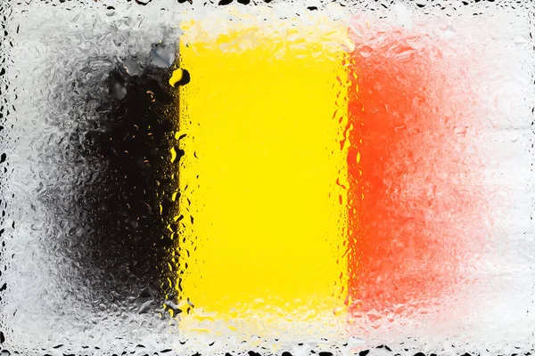 Belgium flag. Flag of Belgium on the background of water drops. Flag with raindrops. Splashes on glass. Abstract background