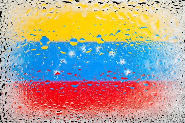 Flag of Venezuela. Venezuela flag on the background of water drops. Flag with raindrops. Splashes on glass. Abstract background