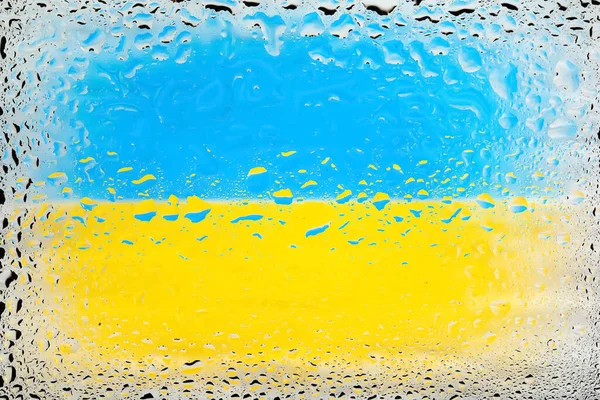 Flag of Ukraine. Ukrainian flag on the background of water drops. Flag with raindrops. Splashes on glass. Abstract background