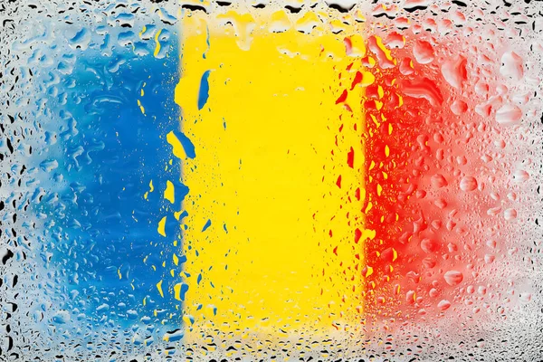 Flag of Romania. Romania flag on the background of water drops. Flag with raindrops. Splashes on glass. Abstract background