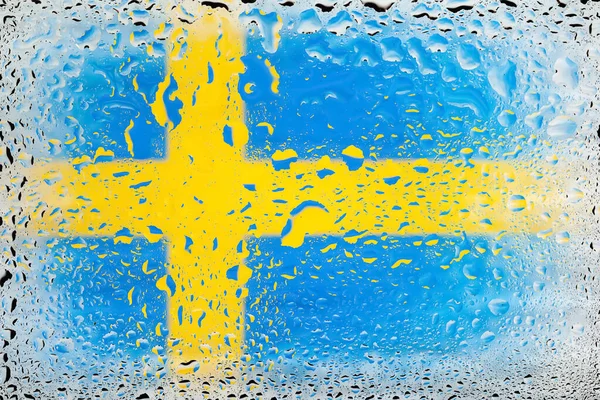 Flag of Sweden. Sweden flag on the background of water drops. Flag with raindrops. Splashes on glass. Abstract background