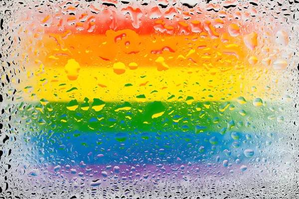 Flag of LGBT. LGBTq flag on the background of water drops. Flag with raindrops. Splashes on glass. Abstract background