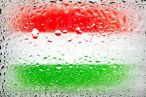 Flag of Hungary. Hungary flag on the background of water drops. Flag with raindrops. Splashes on glass. Abstract background
