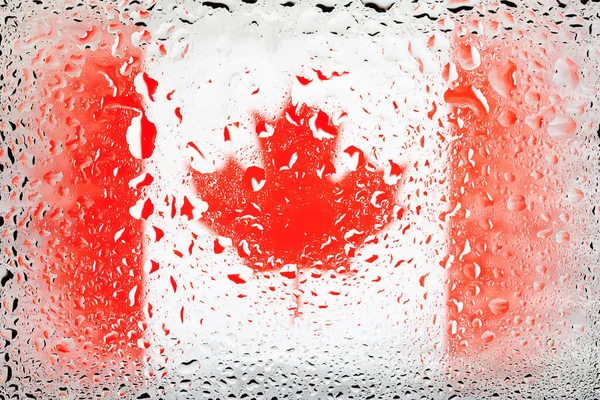 Flag of Canada. Canada flag on the background of water drops. Flag with raindrops. Splashes on glass. Abstract background