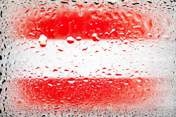 Flag of Austria. Austria flag on the background of water drops. Flag with raindrops. Splashes on glass. Abstract background