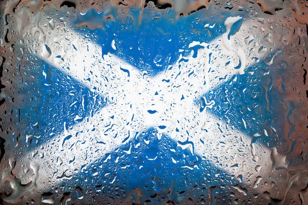Scotland flag. Scotland flag on the background of water drops. Flag with raindrops. Splashes on glass. Abstract background