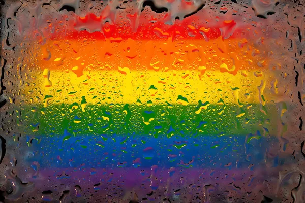 LGBT flag. LGBTq flag on the background of water drops. Flag with raindrops. Splashes on glass. Abstract background