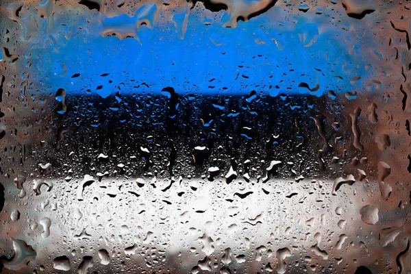 Estonia flag. Estonia flag on the background of water drops. Flag with raindrops. Splashes on glass. Abstract background