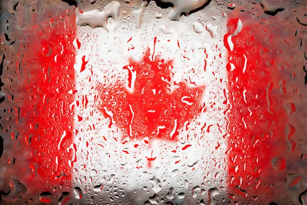 Canada flag. Canada flag on the background of water drops. Flag with raindrops. Splashes on glass. Abstract background