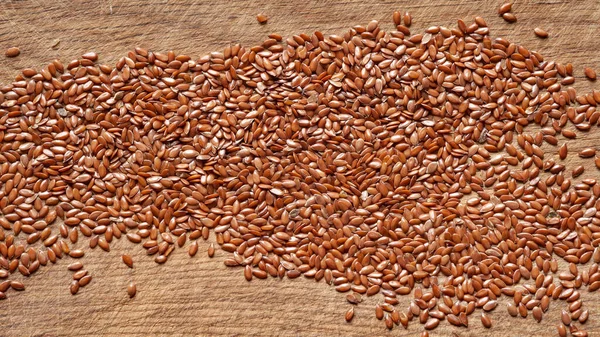 Flax seeds. Flax seeds are scattered on a wooden board. Omega 3. Healthy nutrition. Top view