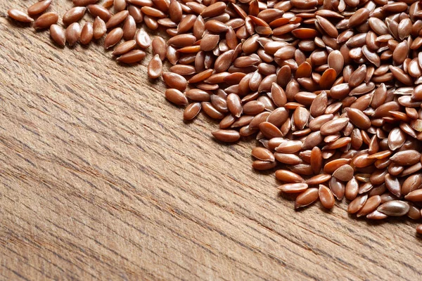 Flax seeds. Flax seeds are scattered on a wooden surface. Omega 3. Healthy nutrition. Copy space. Top view