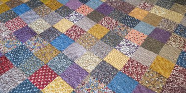 Yamalı olarak yazdırın. Yama izli yorgan örtü. Geometrik büyük desen. Seçici yumuşak odak