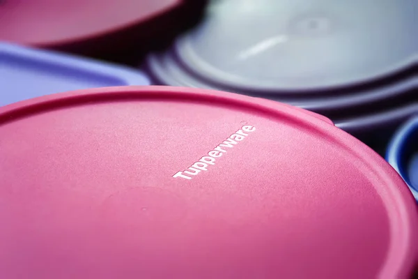 Logolu plastik kapaklar. Tupperware marka kapaklar tam kare. Sığ alan derinliğinde desenli bir görüntü. Ukrayna. Kyiv. Haziran 02.2023